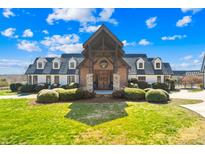 Stately home with brick and timber entrance, manicured lawn, and dormer windows at 12613 Oak Grove Rd, Stanfield, NC 28163
