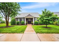 Charming home featuring stone accents, well-manicured lawn, and a welcoming front entrance at 13407 Hazelbrook Ln, Cornelius, NC 28031