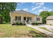 Charming home with a cozy front porch and landscaped yard for a warm, inviting appeal at 1406 W Walnut Ave, Gastonia, NC 28052