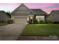Charming single-Gathering home with a two-car garage, complemented by a lush lawn and manicured landscaping at 1409 Tupelo Rd, Clover, SC 29710