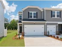 Two-story townhome with gray siding, black shutters, two car garage, and well-manicured landscaping at 1712 Braemar Village Dr, Monroe, NC 28110