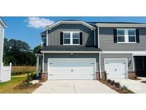 Charming townhome featuring a two-car garage, gray siding, and tidy landscaping at 1712 Braemar Village Dr, Monroe, NC 28110