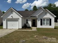Charming one-story home featuring an attached garage, dark roof, and well-kept lawn at 181 Mott Rd, Mooresville, NC 28115