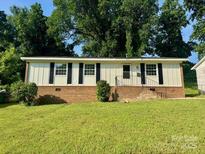Charming single-story home featuring black window shutters and a well-maintained front yard at 2020 Longleaf Dr, Charlotte, NC 28210
