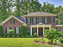 Stately two-story brick home with manicured lawn and mature trees at 2129 Halford Pl, Charlotte, NC 28211
