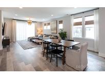 Open-concept living and dining area with contemporary furnishings and hardwood floors, perfect for entertaining at 2254 Electric Ln, Charlotte, NC 28205