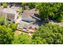 Aerial view showcases fenced backyard, red brick patio and mature shade trees at 7129 Stonington Ln, Charlotte, NC 28227