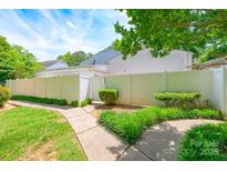 A beautiful, fenced backyard with lush green grass and a concrete walkway at 7129 Stonington Ln, Charlotte, NC 28227