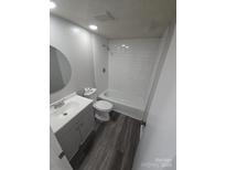 Well-lit bathroom with white subway tile surround and gray wood-look flooring at 7129 Stonington Ln, Charlotte, NC 28227
