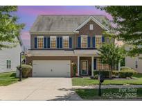 Charming two-story home boasts blue shutters, brick accents, and a well-manicured front lawn at 7318 Agnew Dr, Charlotte, NC 28278