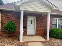 Charming brick home featuring a covered front entrance with stately white columns and a well-manicured lawn at 102 Brandywine Ne Dr # I-1, Conover, NC 28613