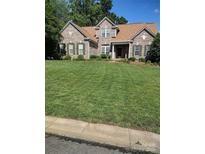 Charming brick home with manicured lawn, complemented by lush landscaping and classic shuttered windows at 1117 Yarrow St, Matthews, NC 28104