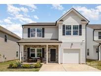 Charming two-story home with stone accents, front porch seating, and attached one car garage at 1121 Freeman View Dr, Albemarle, NC 28001