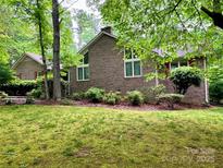 Charming brick home with well-maintained lawn, mature trees, and lush landscaping at 1623 Arbor Way, Albemarle, NC 28001