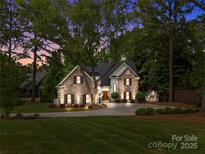 Charming stone and siding home with a well-manicured lawn and a playful shed nestled in a lush, tree-filled landscape at 19614 Meta Rd, Cornelius, NC 28031
