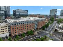 Brick apartment building with black trim, surrounded by streets, shops, and offices in a vibrant cityscape at 2125 Southend Dr # 448, Charlotte, NC 28203