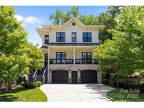 Charming two-story home featuring a brick facade, a black 2-car garage, and an inviting second-story porch at 2925 Westfield Rd, Charlotte, NC 28209