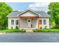 Charming home with light siding, covered front porch, and well-manicured lawn at 322 S Hill St, Gastonia, NC 28052