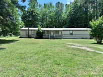 Charming single-story home with a covered front porch and spacious front yard surrounded by lush trees at 341 Austin Dr, York, SC 29745