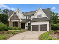 Beautiful two-story home boasts stone accents, a two-car garage, and a well-manicured lawn at 400 Hunter Ln, Charlotte, NC 28211