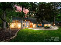 Charming home featuring stone accents, a well-manicured lawn, and lush landscaping with trees surrounding the property at 4609 Rounding Run Rd, Charlotte, NC 28277