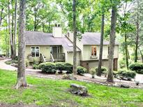 Charming home with a two-car garage surrounded by lush greenery and trees at 50 Honeysuckle Woods, Lake Wylie, SC 29710