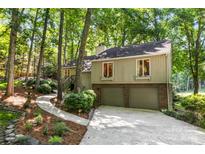 Charming home nestled in the trees, featuring a two-car garage and inviting landscaping at 50 Honeysuckle Woods, Lake Wylie, SC 29710