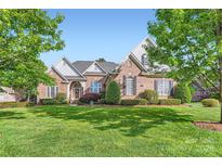 Beautiful brick home boasts lush lawn, manicured landscaping and mature trees at 534 Ballymote Ct, Matthews, NC 28104