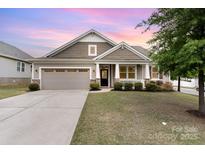 Charming single-Gathering home with a two-car garage, covered porch, and manicured lawn at 7113 Meridale Forest Dr, Charlotte, NC 28269