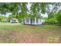 Charming home with light blue siding, a cozy screened-in porch, and a well-maintained yard at 917 Laye St, Belmont, NC 28012