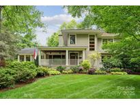 Charming home featuring a covered porch, lush landscaping, and a well-manicured lawn at 920 Habersham Dr, Charlotte, NC 28209