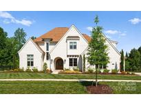 Stunning white brick home with a manicured lawn, arched entry, and a warm, inviting presence at 10201 Laurier Ln, Huntersville, NC 28078