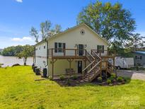 Charming raised bungalow featuring a wooden deck, well-maintained lawn, and easy water access at 1077 Jackson Rd, Fort Lawn, SC 29714