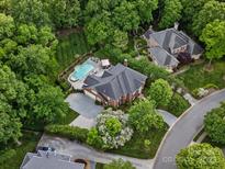 Stunning aerial view of a private estate featuring a pool, lush landscaping, and well-manicured lawns at 13029 Whisper Creek Dr, Charlotte, NC 28277
