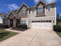 Two-story home featuring a two-car garage and stone-accented front porch at 14837 Dungannon Ct, Charlotte, NC 28278