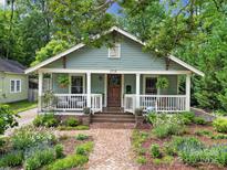 Charming home with a covered front porch, brick pathway, and lush landscaping at 1713 Allen St, Charlotte, NC 28205