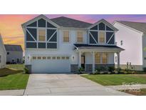 Inviting two-story home with a two-car garage, craftsman architecture, and manicured lawn at 2021 Boynton St, Charlotte, NC 28269