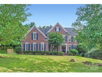 Traditional brick home featuring blue shutters and manicured landscaping at 2215 Maycroft Dr, Charlotte, NC 28262