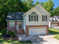 Charming two-story home features a brick and siding exterior, attached garage, and well-maintained lawn at 319 Beacon Hills Dr, Gastonia, NC 28056