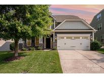 Charming two-story home featuring a well-manicured lawn, attached garage, and beautiful stone accents at 4324 Falls Lake Sw Dr, Concord, NC 28025