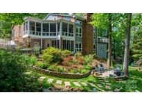 Expansive brick home featuring a spacious screened porch and beautifully landscaped backyard with lush gardens and a seating area at 4647 16Th Street Ne Pl, Hickory, NC 28601