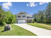 Charming two-story home with a gray exterior, well-manicured lawn, and inviting two-car garage at 9115 Providence S Rd, Waxhaw, NC 28173