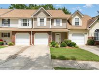 Inviting townhome featuring a one-car garage, manicured lawn, and classic architectural details at 10421 Columbia Crest Ct, Charlotte, NC 28270