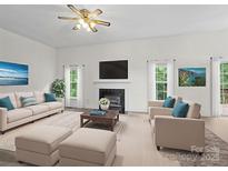 Bright living room features a decorative fireplace, plush seating, and modern decor at 12317 Panthersville Dr, Charlotte, NC 28269