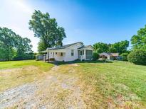 Charming single story home featuring a screened in porch, mature trees, and a large front yard at 1468 Hilltop St, Albemarle, NC 28001