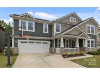 Charming two-story home with a two car garage, basketball hoop, landscaped yard, and covered front porch at 1601 Calder Dr, Indian Trail, NC 28079