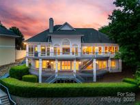 Expansive rear exterior with multiple decks offers stunning views at sunset at 16108 Woolwine Rd, Charlotte, NC 28278