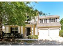 Charming home featuring a welcoming porch, lush landscaping, and a two-car garage at 17204 Caldwell Track Dr, Huntersville, NC 28078