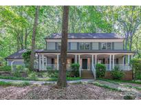 Charming two-story home with a welcoming front porch, surrounded by lush landscaping and mature trees at 2310 Vestry Pl, Charlotte, NC 28270