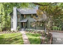 Charming home with an olive green exterior, stone chimney, and landscaped front yard at 4316 Old Saybrook Ct, Charlotte, NC 28211